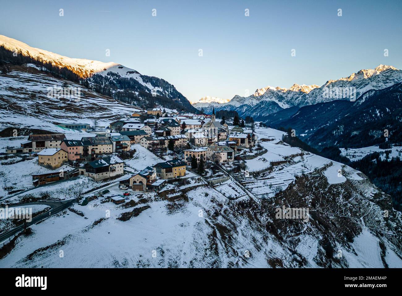 Luftaufnahme eines kleinen Dorfes zwischen den Bergen im Winter in Guarda, Schweiz. Stockfoto