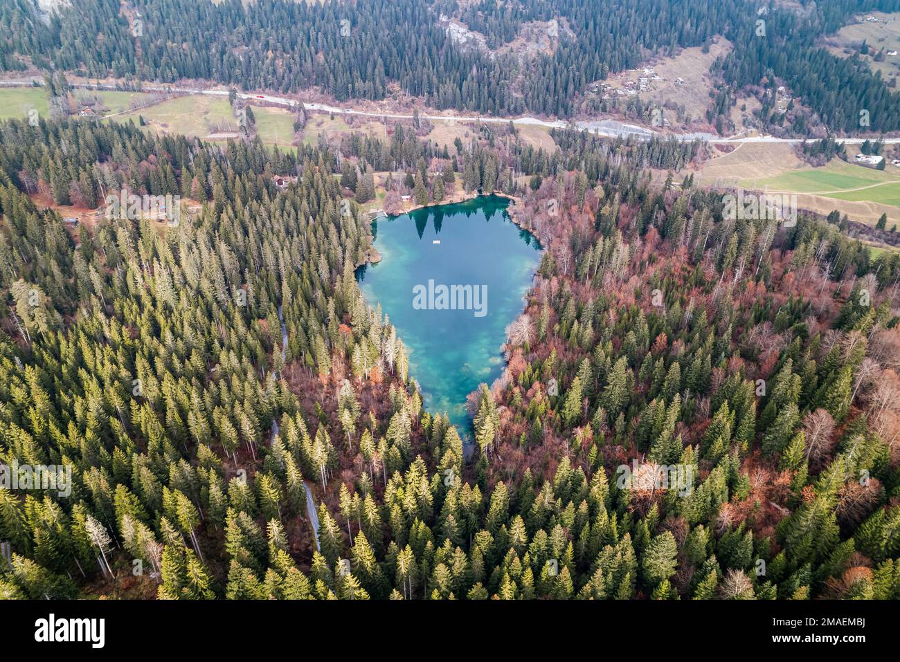 Beatufil aus der Vogelperspektive auf den blauen Wassersee in einem Schweizer Wald. Stockfoto