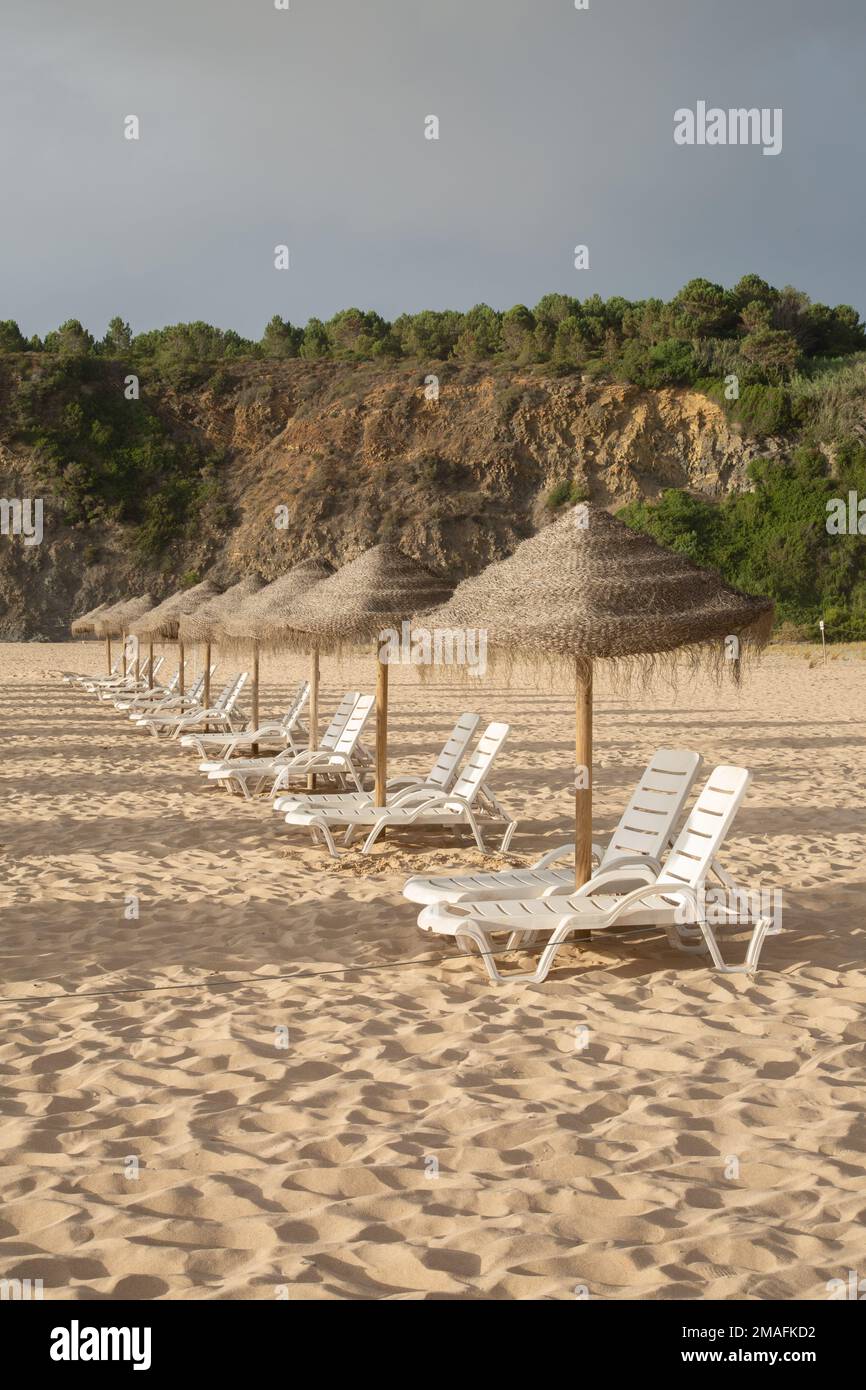 Sonnenliegen am Strand von Odeceixe, an der Algarve und in Portugal Stockfoto