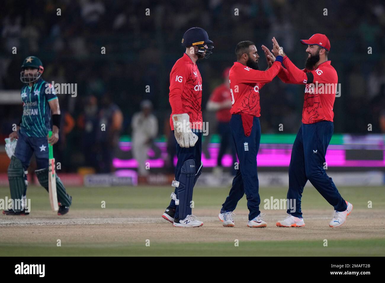 England's Adil Rashid, second right, celebrates with teammates the dismissal of Pakistan's captain Babar Azam during the first T20 cricket match between Pakistan and England, in Karachi, Pakistan, Tuesday, Sept. 20, 2022. (AP Photo/Anjum Naveed) Stockfoto