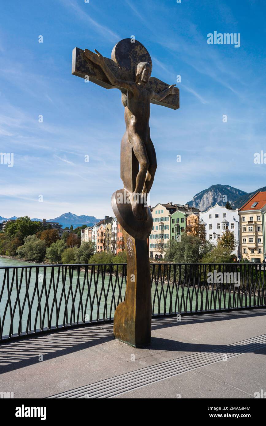 Christentum Europa, Blick auf die Bronzeskulptur Crucifix von Rudi Wach auf der Innbrücke, eine Brücke über den Fluss Inn in Innsbruck, Österreich Stockfoto
