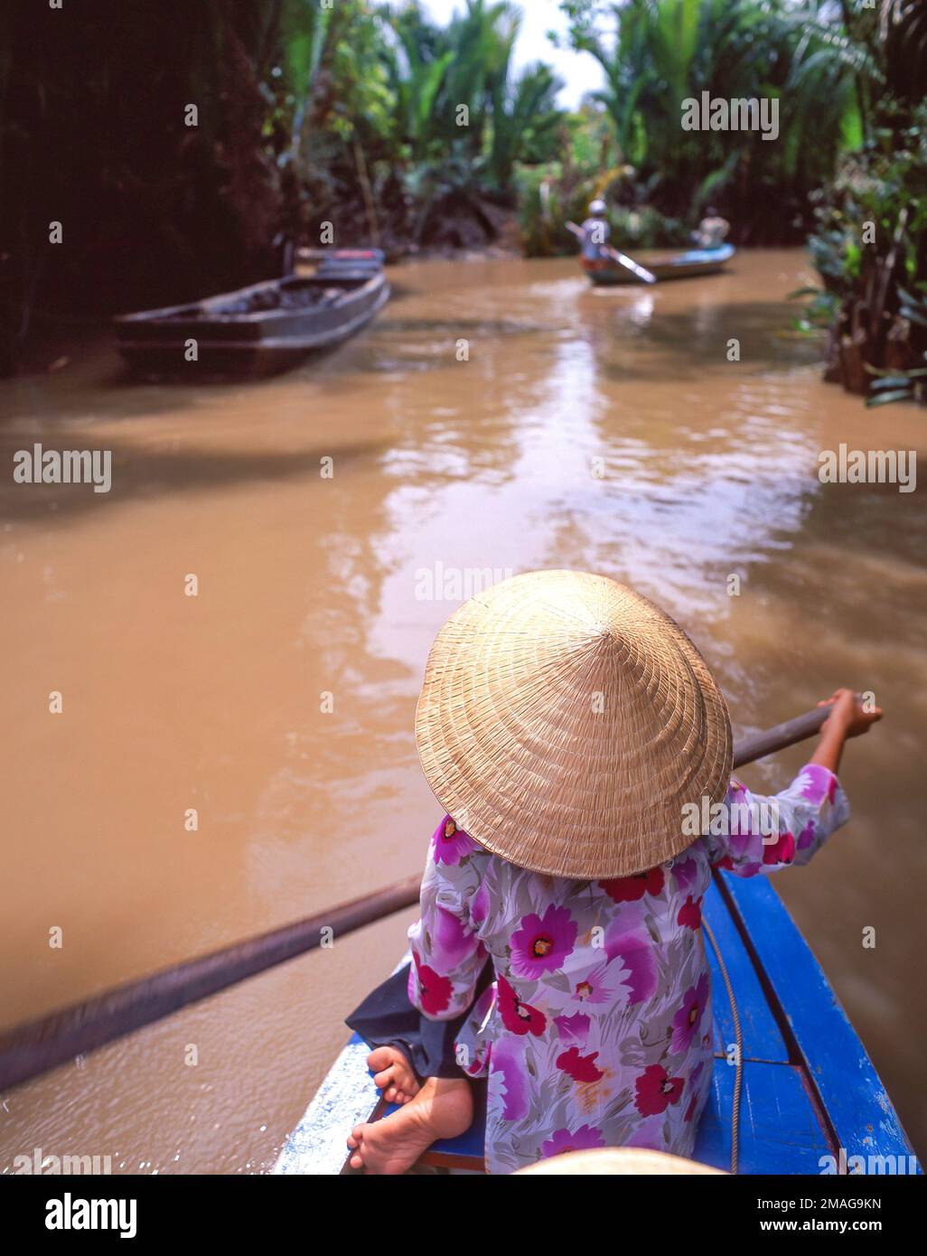 Vietnamesische Frau mit konischem Nón lá-Hut, die Sampan durch das Mekong-Delta, Einhorn-Insel, My Tho, Sozialistische Republik Vietnam paddelt Stockfoto