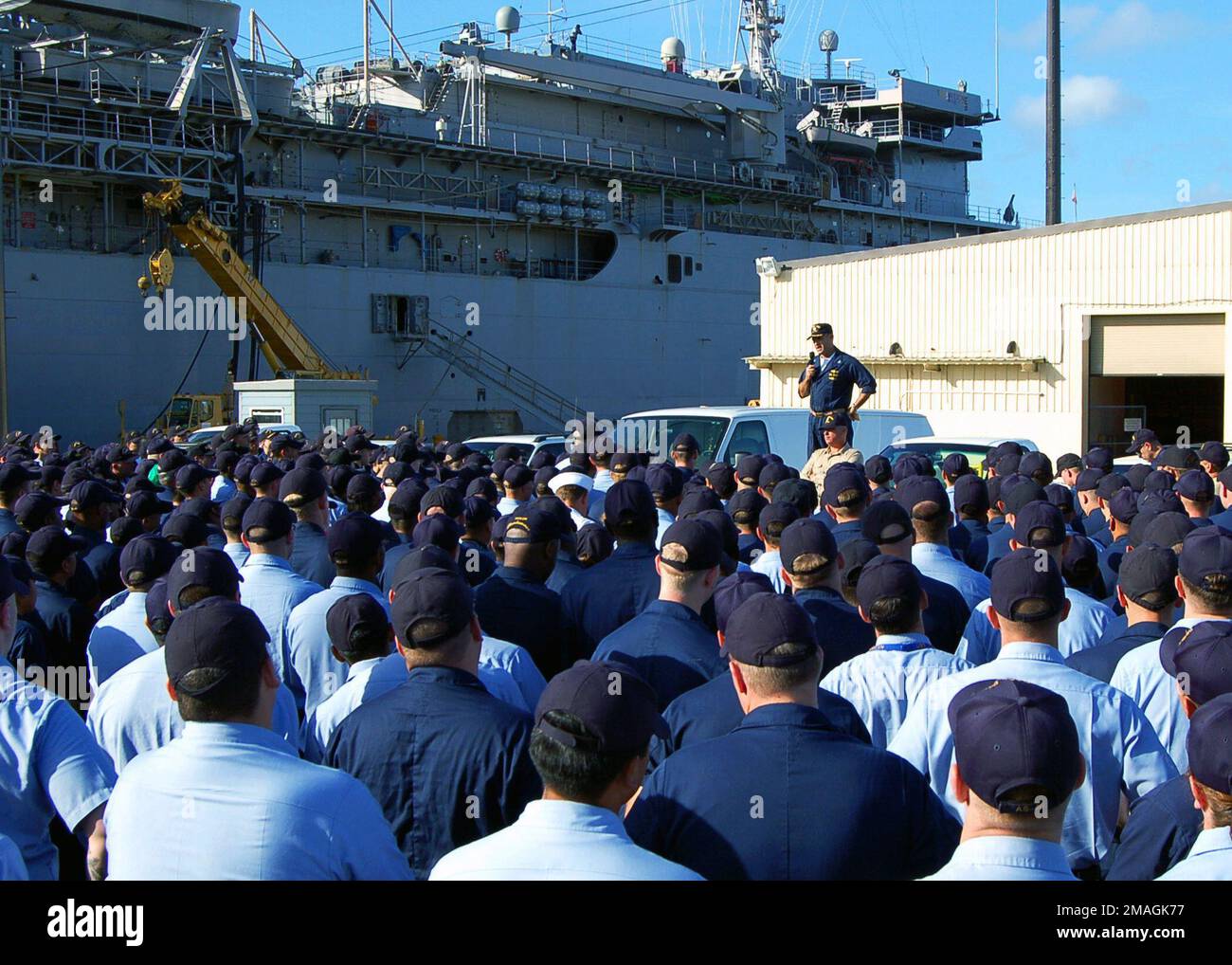 061204-N-3228J-001. [Complete] Bildunterschrift: USA Navy (USN) CAPT. Leo Goff, kommandierender Offizier, L.Y. Spear Class Submarine Tender USS FRANK CABLE (AS 40) spricht am 4. Dezember 2001, dem Montag nach einer Boiler-Explosion am Wochenende an Bord des Schiffes, an der Besatzung. Der Unfall vom 1. Dezember setzte überhitzten Dampf frei und verletzte sechs Seeleute schwer. Sie wurden stabilisiert und über das Wochenende von Guam zum Brooke Army Medical Center in San Antonio, TX, geflogen. USN CAPT. Goff rief alle an, um die Crew über die Bedingungen ihrer Schiffskameraden zu informieren und den Weg vor dem Schiff zu besprechen. Das FRANK-KABEL ist vorgezogen Stockfoto