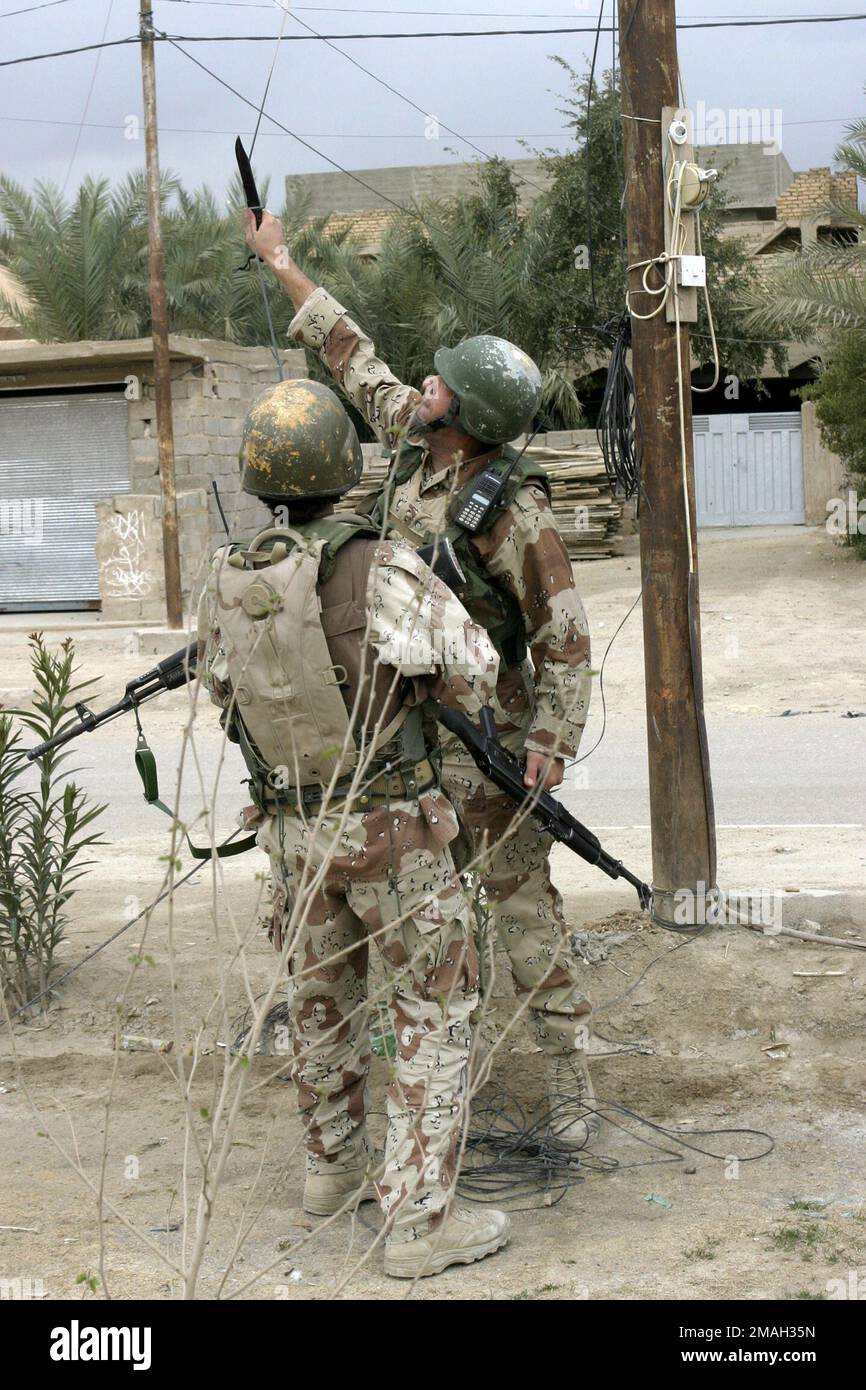070317-M-2819S-016. [Complete] Szene Caption: Ein irakischer Soldat durchtrennt während einer Fußpatrouille eine verdächtige Nabelschnur. Soldaten der irakischen Armee und Marines, die dem 2. Bataillon, der 2. Brigade und DER 1. Division der irakischen Armee angeschlossen sind, führen am 7. März 2007 als Übung der kombinierten Streitkräfte montierte Sicherheitspatrouillen durch. Das Regimentsattenteam 6 wird zusammen mit der II Marine Expeditionary Force zur Unterstützung der Operation Iraqi Freedom in der Provinz Anbar im Irak (multinationale Streitkräfte im Westen) eingesetzt, um die irakischen Sicherheitskräfte zu entwickeln und die Entwicklung einer offiziellen Rechtsstaatlichkeit zu erleichtern Stockfoto
