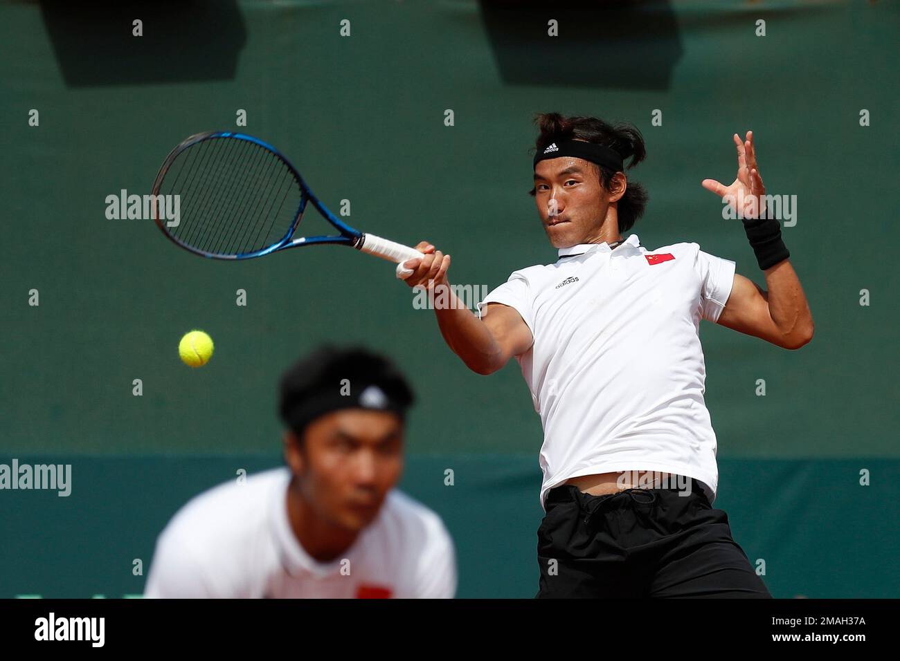 China's Bu Yunchaokete returns the ball to Uruguay's Martin Cuevas and Ignacio Carou as his teammate Te Rigele looks on during a Davis Cup World Group II doubles tennis match in Montevideo, Uruguay, Saturday, Sept. 17, 2022. (AP Photo/Matilde Campodonico) Stockfoto