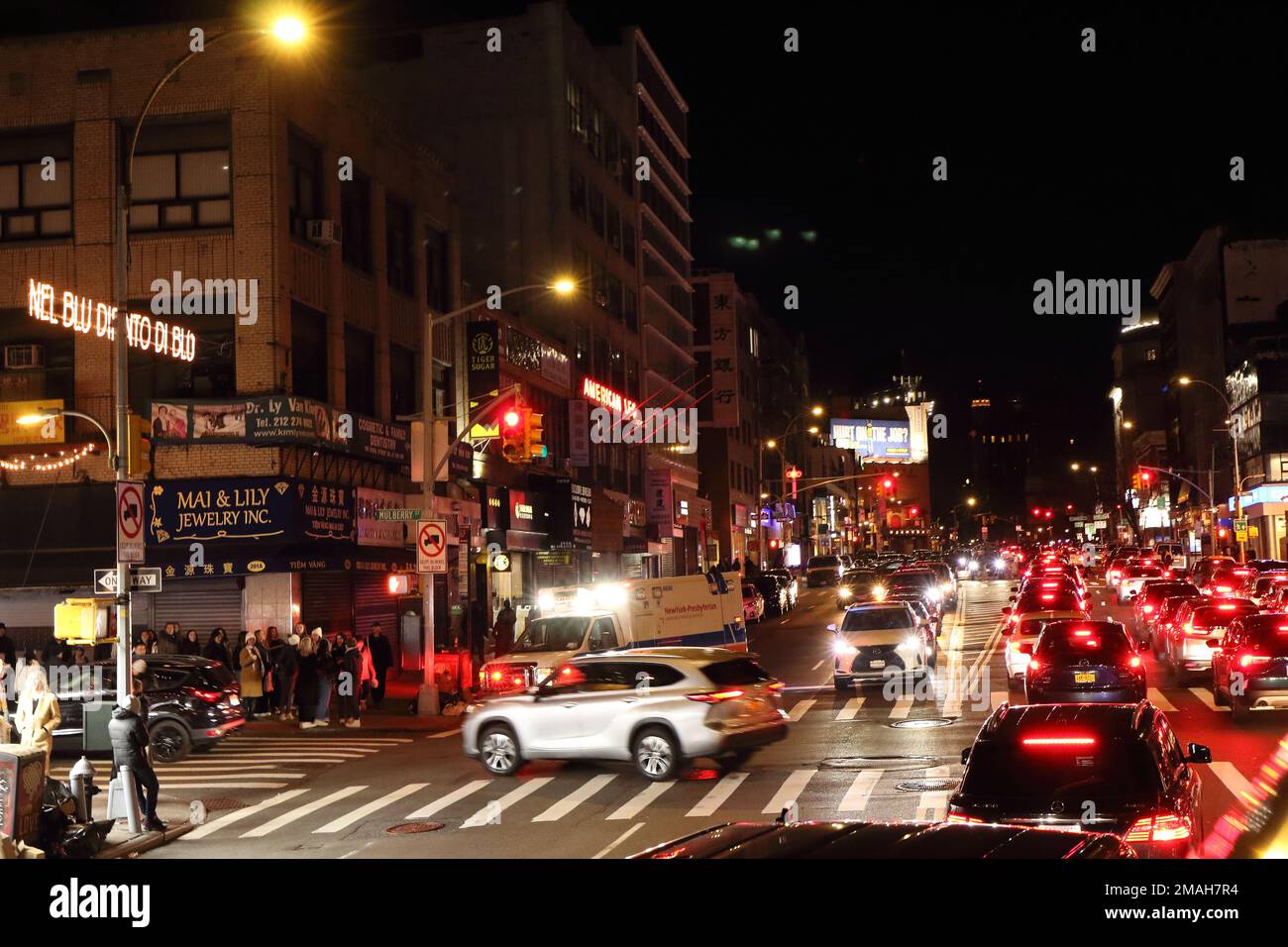 New York City Kreuzung von Canal Street und Mulburry Street. Nachtsicht Schlange, Verkehr, 4-Wege-Zebra, das viele Leute überquert, die darauf warten, überqueren zu müssen Stockfoto
