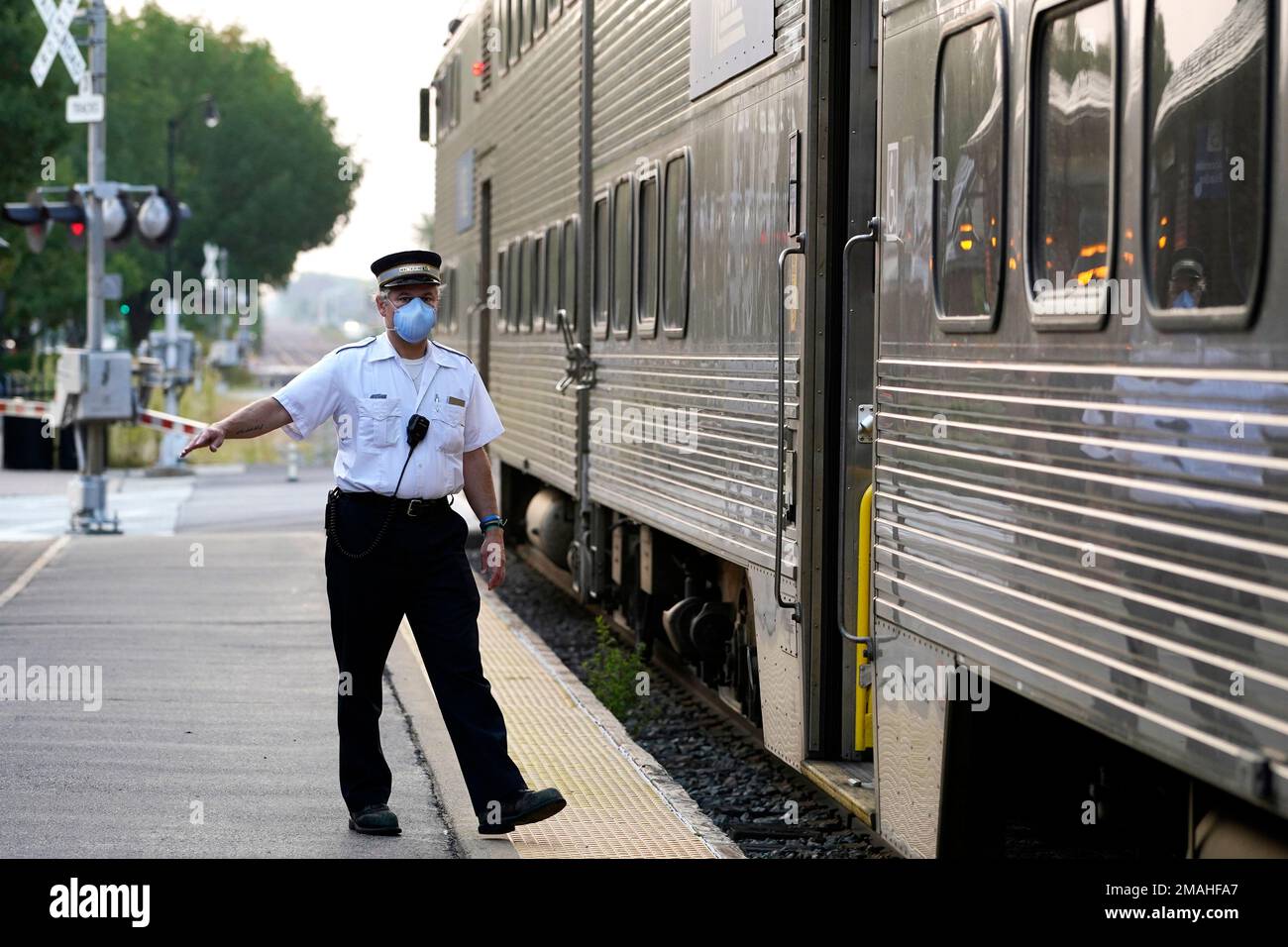 A Metra conductor signals for all clear at the Metra Arlington Heights station Thursday, Sept. 15, 2022, in Arlington Heights, Ill. President Joe Biden said Thursday a tentative railway labor agreement has been reached, averting a potentially devastating strike before the pivotal midterm elections. (AP Photo/Nam Y. Huh) Stockfoto