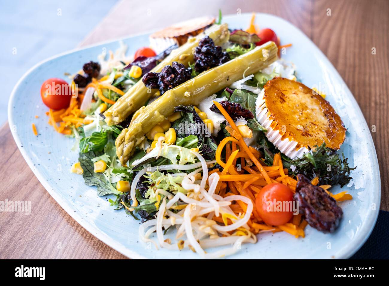 mediterraner Salat mit Spargel, karamellisiertem Ziegenkäse und Nüssen Stockfoto