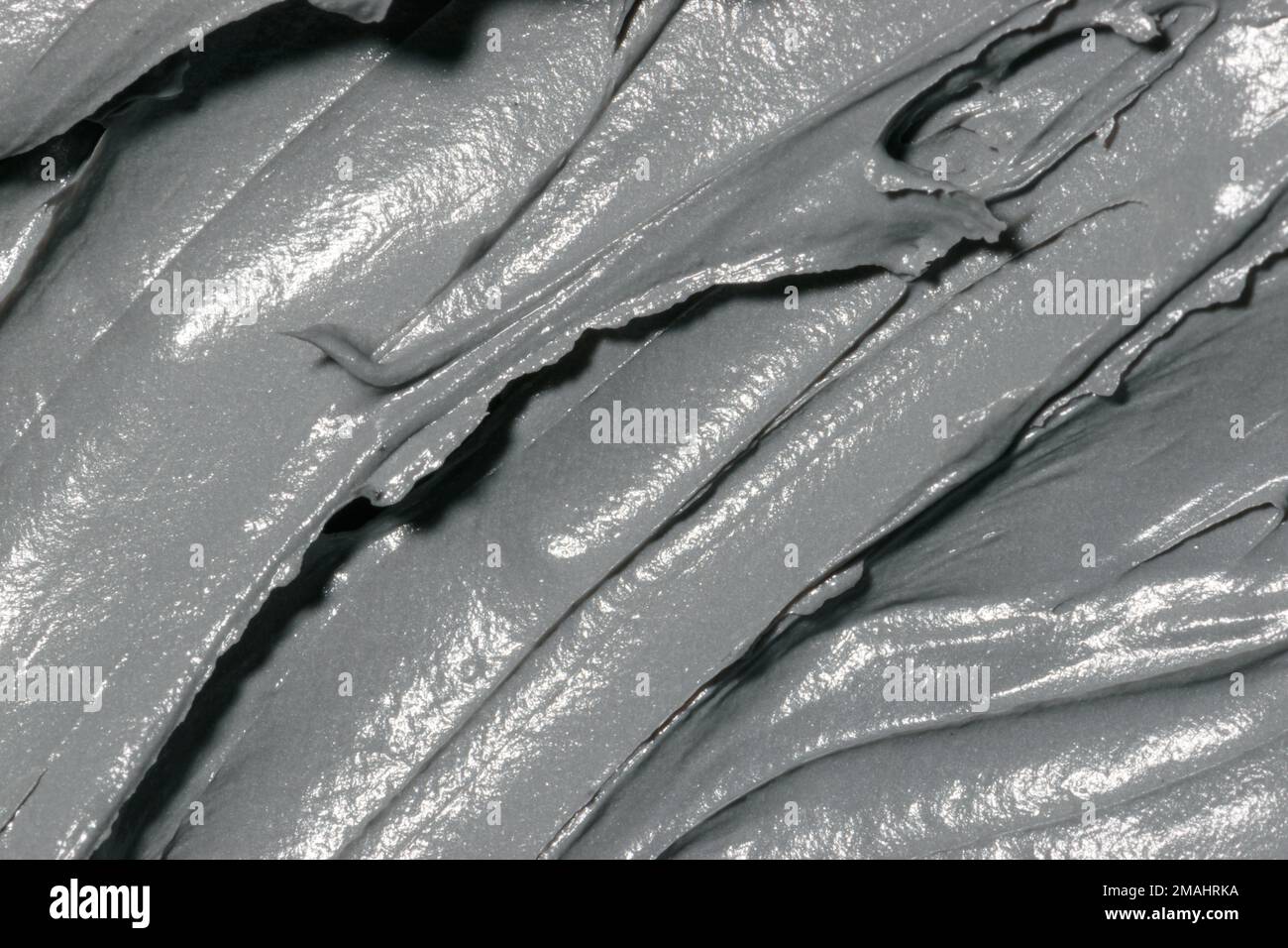 Kosmetische Textur Tonmaske für Gesicht und Körper. Natürliche Spa-Kosmetik. Toter Meeresschlamm, grauer Hintergrund. Draufsicht. Platz für Text Stockfoto