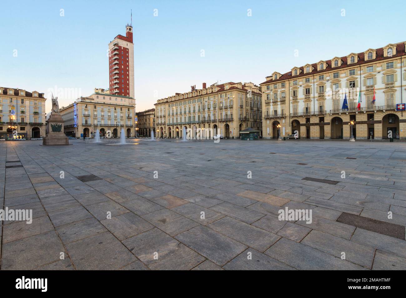Blick auf das antike Gebäude mit Säulengängen und das Hochhaus Torre Littoria auf der Piazza Castello, Turin, Italien. Stockfoto Blick auf das antike Gebäude mit Säulengängen und das Hochhaus Torre Littoria auf der Piazza Castello, Turin, Italien. Stockfoto