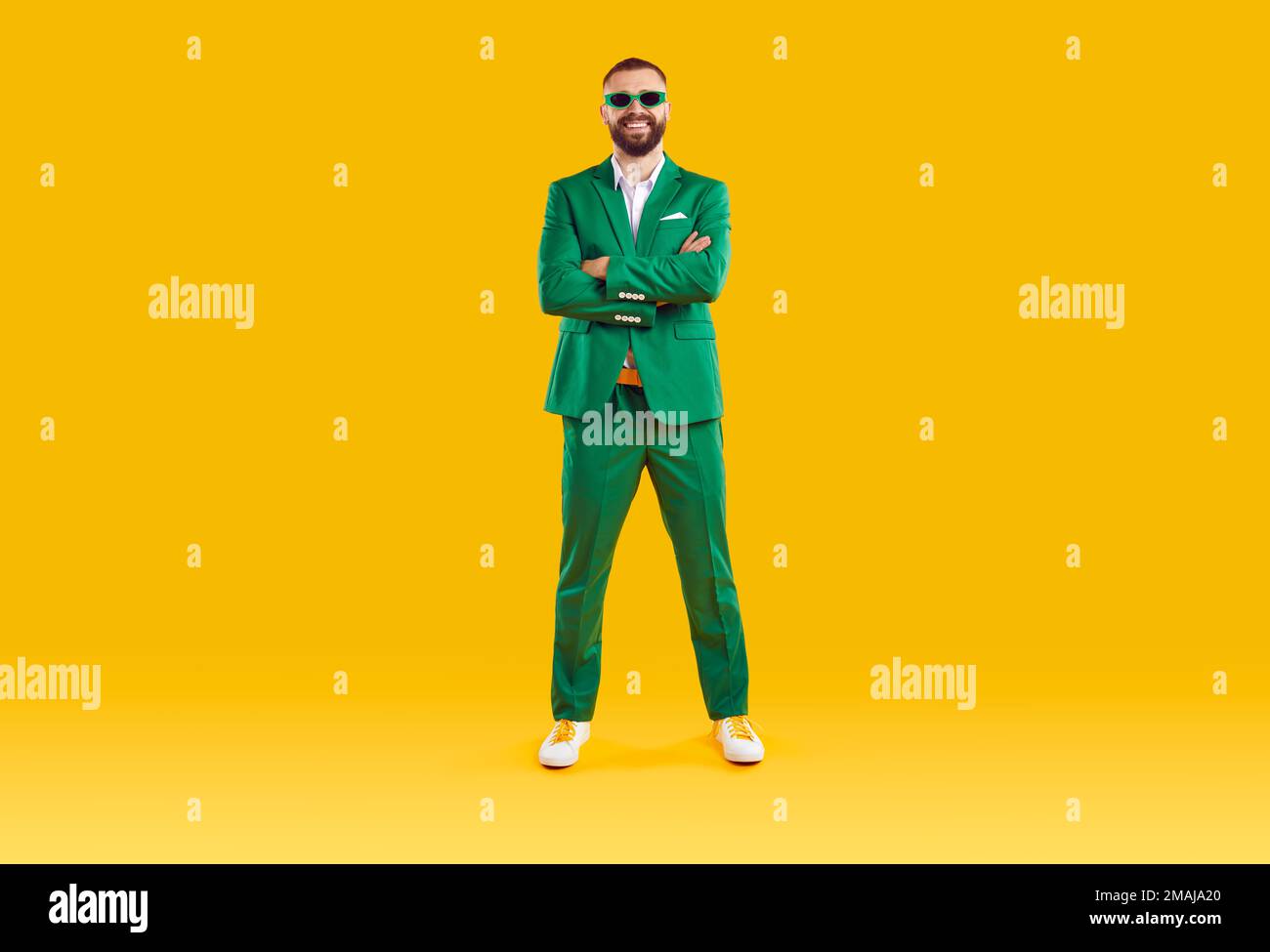 Porträt eines fröhlichen, coolen und fröhlichen Mannes in grünem Anzug und Sonnenbrille der gleichen Farbe. Stockfoto