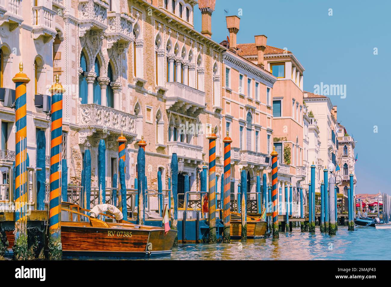 Großer Kanal in Venedig, Italien, mit hölzernen Gondelpfosten vor alten Häusern Stockfoto