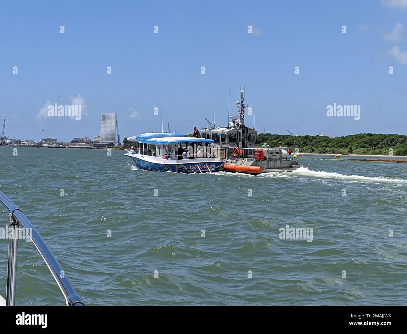 Eine Küstenwache Galveston 45-Fuß Response Boat – mittlere Crew zieht auch die Baywatch, ein Delfin Sightseeing Schiff, das seine Steuerung in der Nähe des Seawolf Park in Galveston, Texas, verloren hat, am 28. Mai 2022. Die Besatzung der Küstenwache schleppte das Schiff und seine 33 Passagiere und Besatzung sicher zum Pier 21 in Galveston. Stockfoto