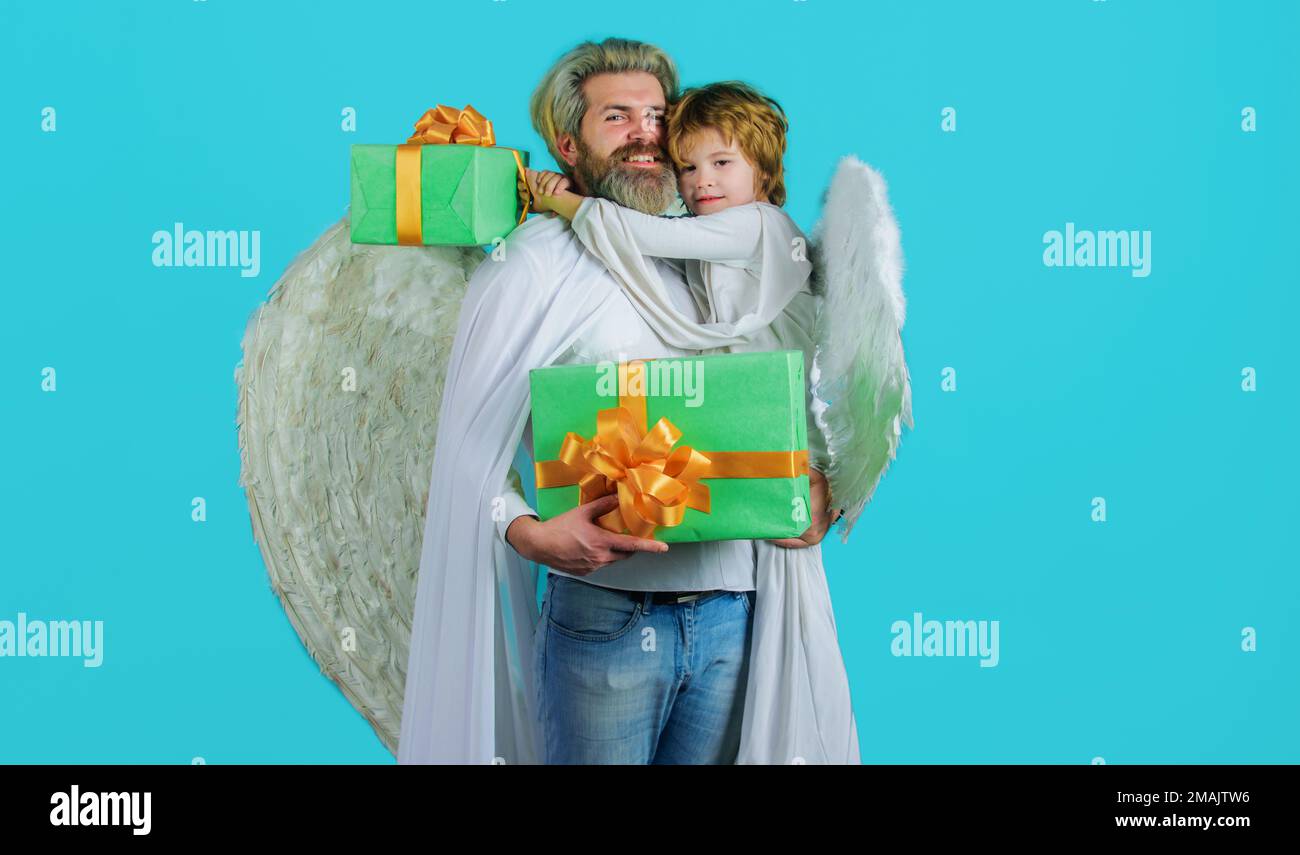 Valentinstag-Feier. Vater und Sohn Engel in weißen Flügeln mit Valentinstagsgeschenk. Stockfoto