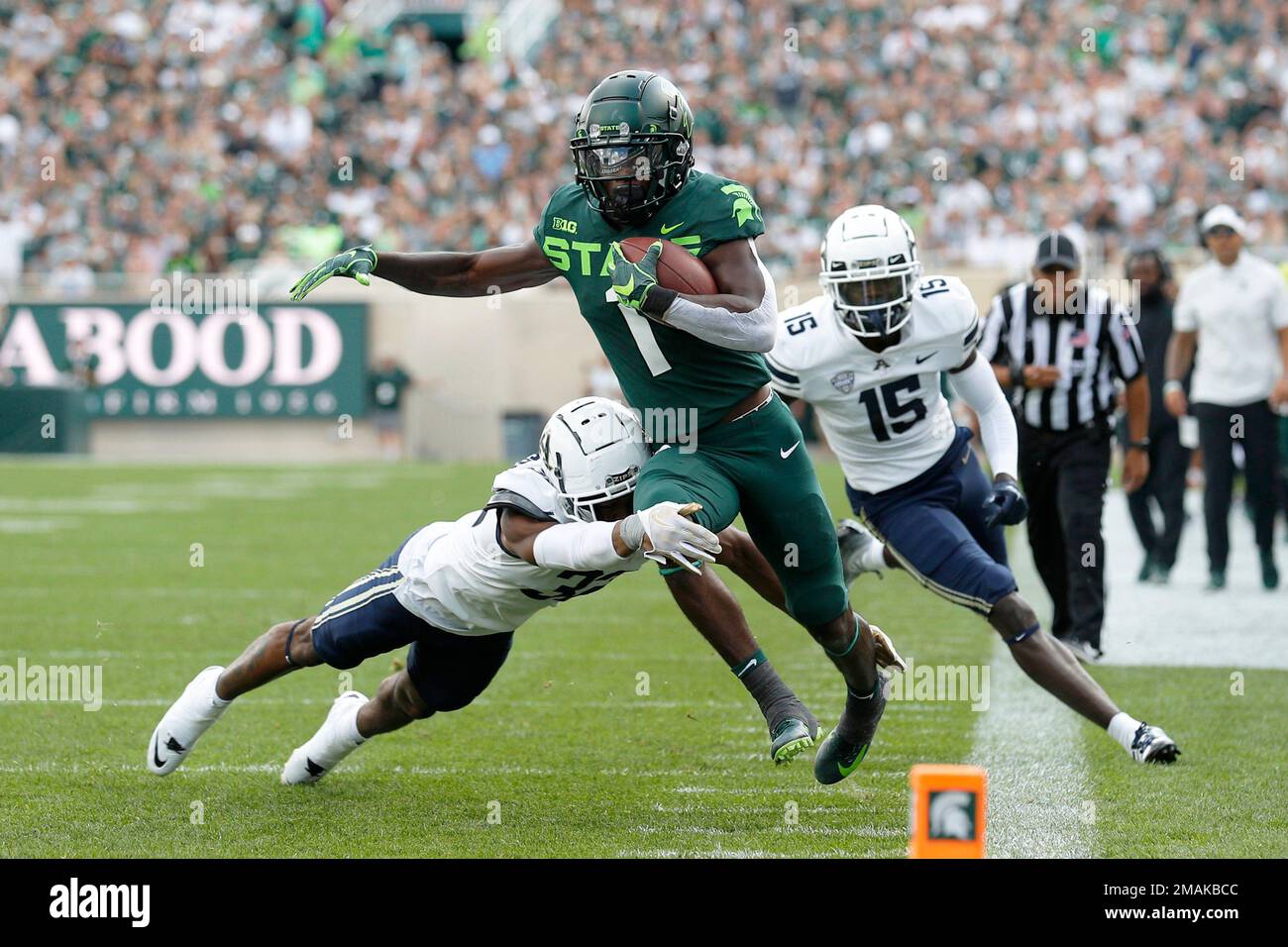Michigan State's Jayden Reed, center, is pushed out of bounds by Akron