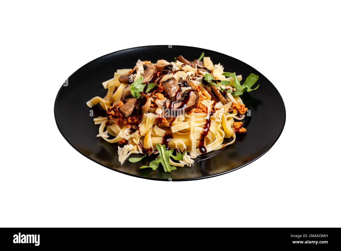Bolognesische Pasta mit Pilzen und mit Rucola gegossener Balsamsauce auf isoliertem Hintergrund Stockfoto