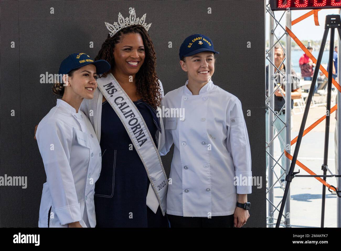 220529-N-VQ947-1356 LOS ANGELES (29. Mai 2022) – die USA Die Küstenwache posiert für ein Foto mit Miss California Jasmin Avalos, Center, bei "Galley Wars", einem Kochwettbewerb an Bord des Battleship Iowa Museum während der Los Angeles Fleet Week am 29. Mai 2022. Die LAFW bietet der amerikanischen Öffentlichkeit Gelegenheit, mit ihren Teams der Marine, des Marine Corps und der Küstenwache zusammenzutreffen und die amerikanischen Seeverkehrsdienste zu erleben. Während der Flottenwoche nehmen Mitglieder des Dienstes an verschiedenen gemeinnützigen Veranstaltungen Teil, präsentieren der Gemeinde Fähigkeiten und Ausrüstung und genießen die Gastfreundschaft von Los angles und seiner Umgebung Stockfoto