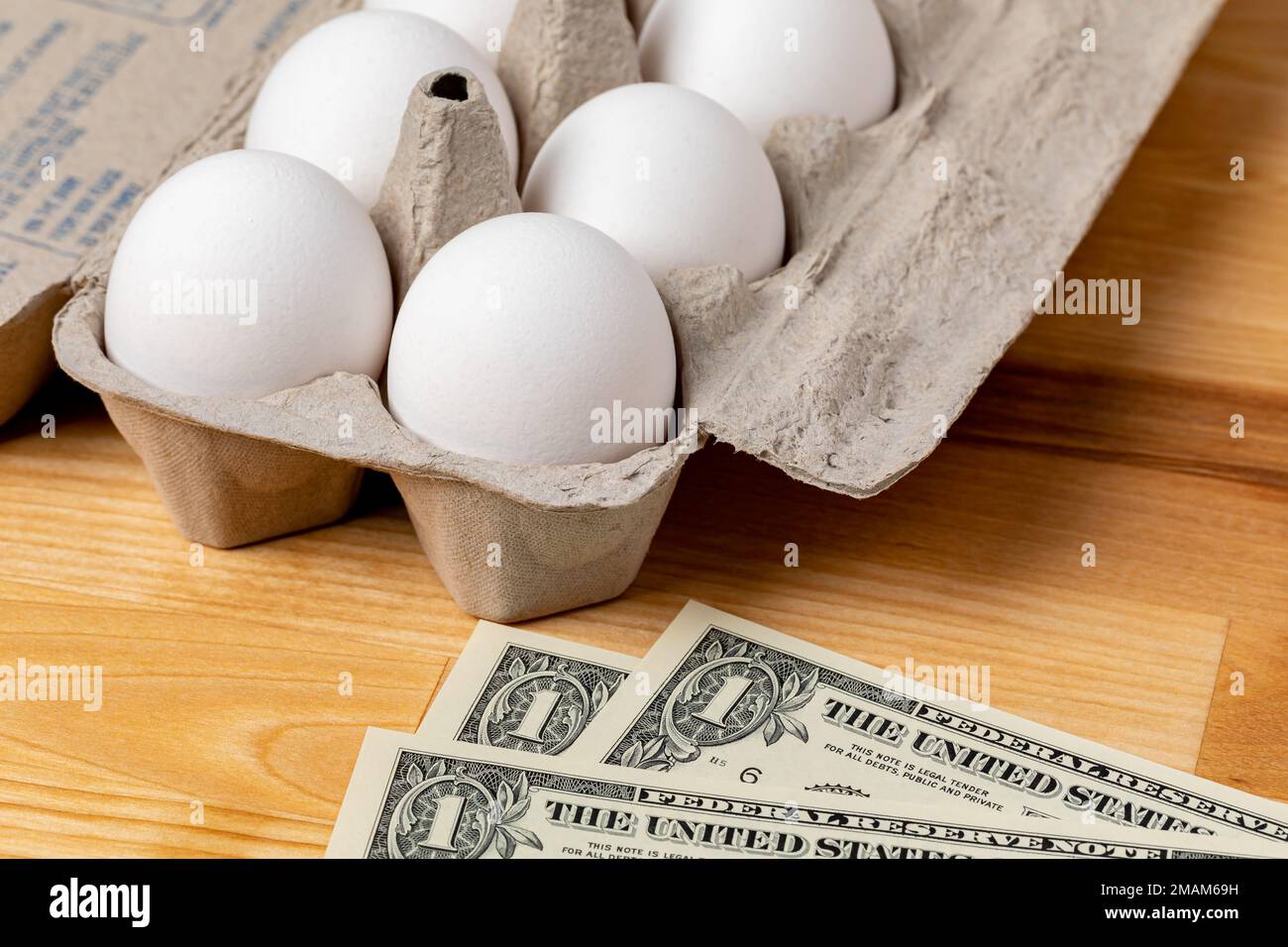 Frische weiße Hühnereier in einem Karton mit Bargeld. Eierpreis, Lebensmitteleinkauf und Geflügelzuchtkonzept. Stockfoto