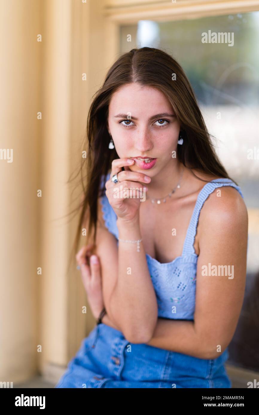Das Hübsche Teenage-Mädchen Sitzt Und Beißt Sich Die Lippe Stockfoto