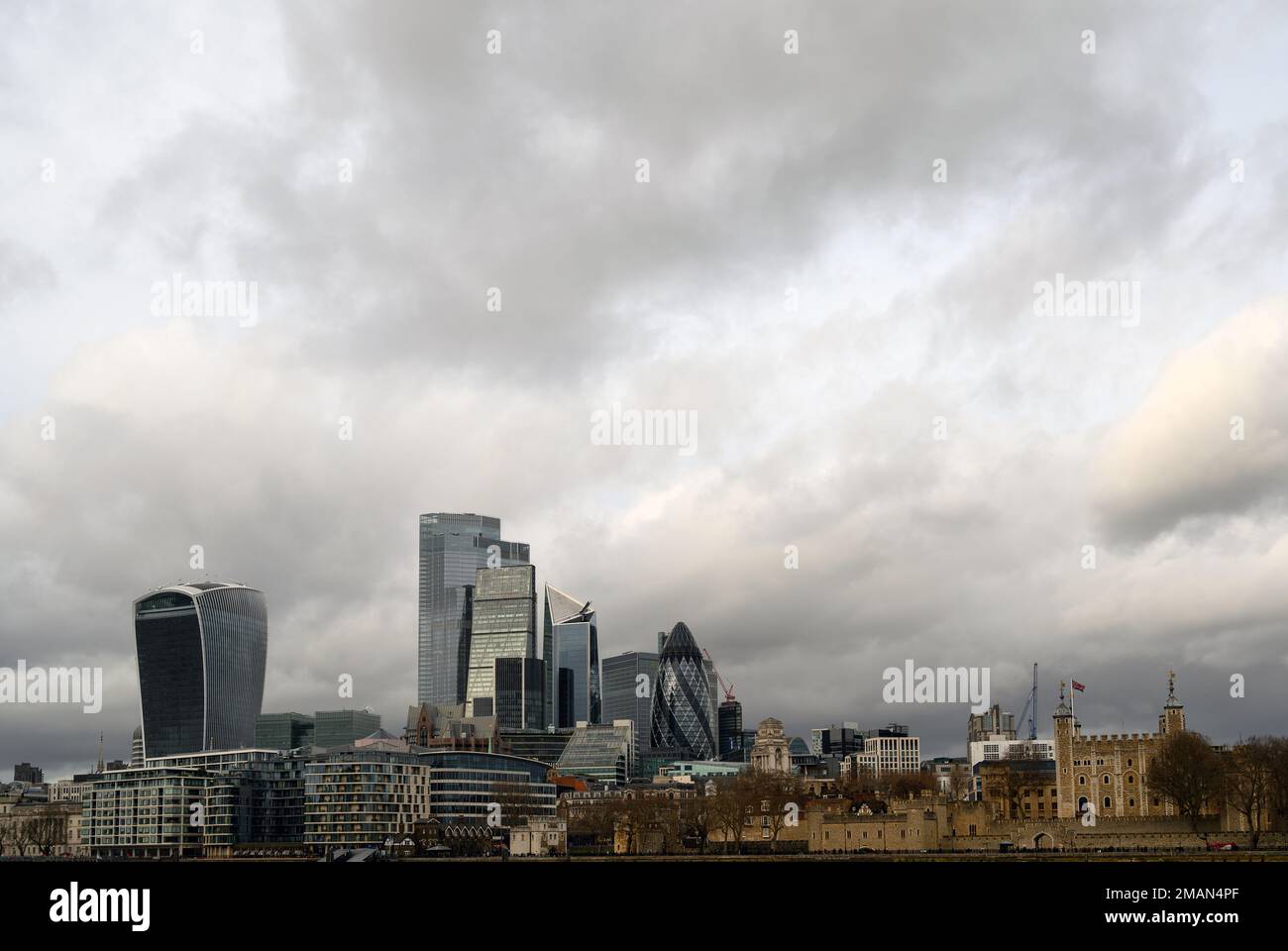 City of London in Großbritannien. Blick über die Themse, die Stadt London und den Tower of London mit dramatischen stürmischen Wolken. Stockfoto