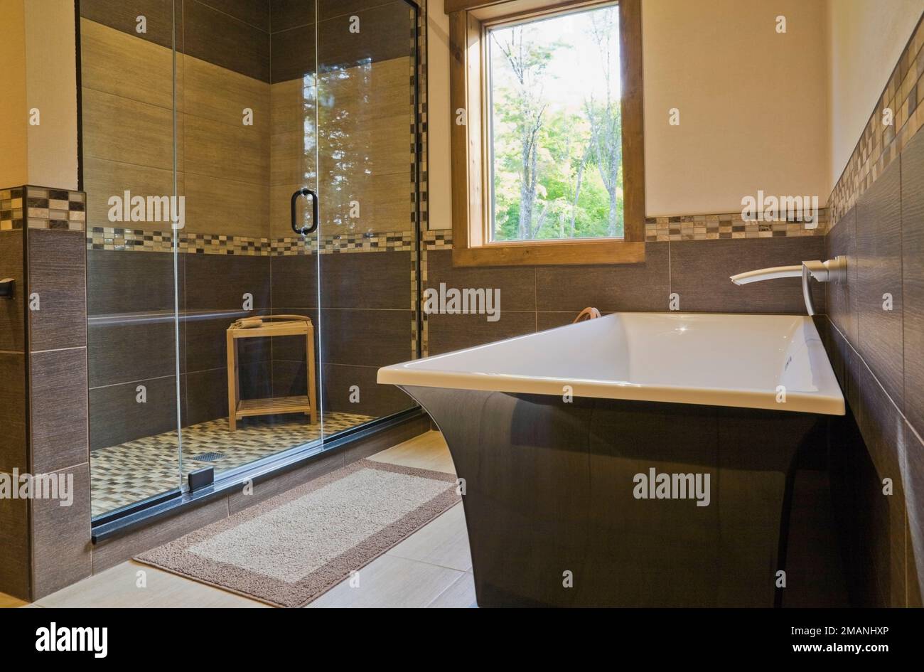 Hauptschlafzimmer en Suite mit freistehender schwarz-weißer Badewanne und Glas-Duschkabine in luxuriösem skandinavischem Holz und Holzrahmen Haus. Stockfoto