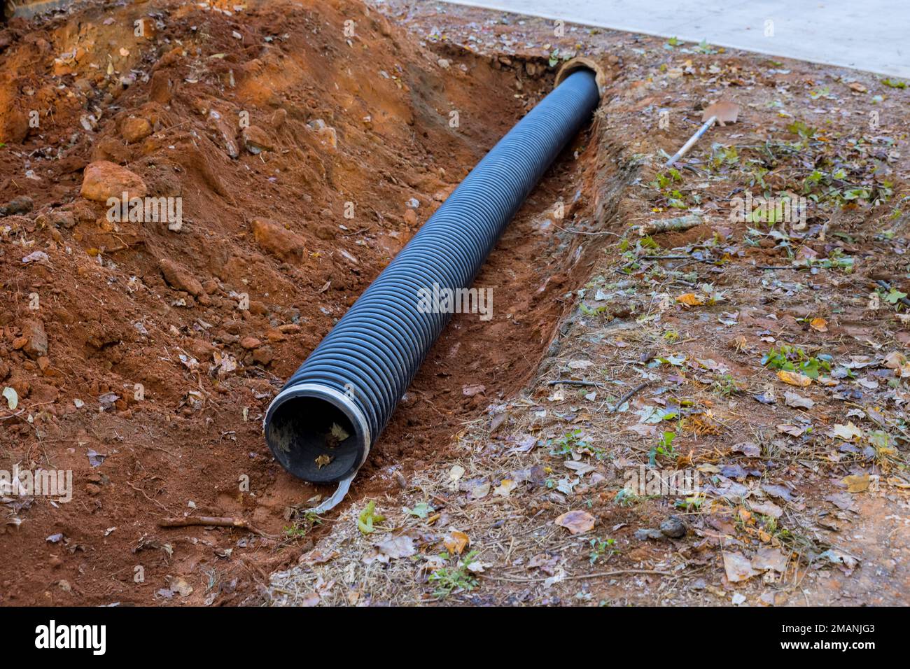 Es werden schwarze PVC-Abwasserrohre unterirdisch verlegt Stockfoto