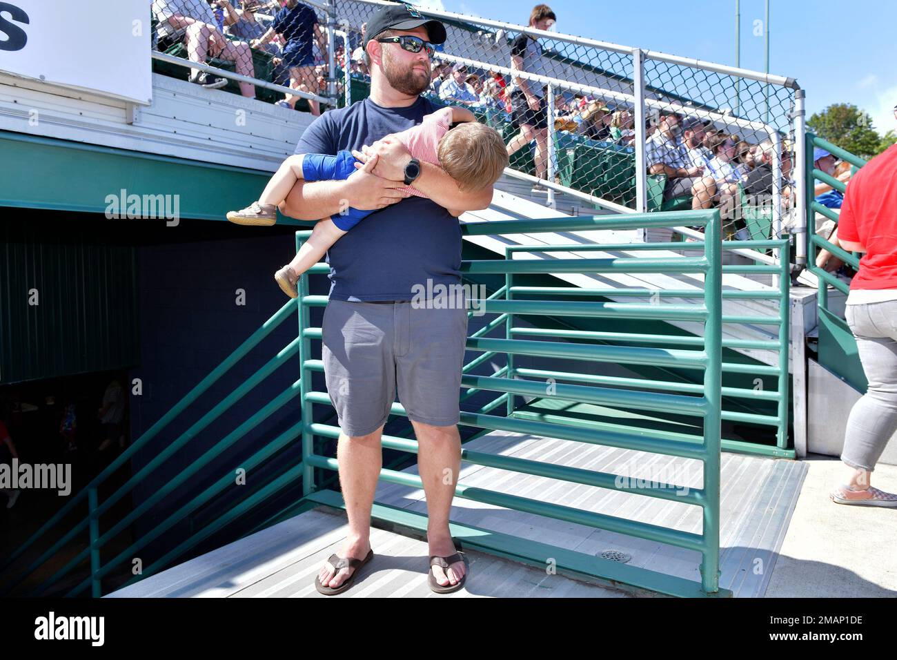 Nathaniel Tillson of Cumberland, Maine, holds his 15-month-old son Easton during the game between the Portland Sea Dogs and the Hartford Yard Goats, Sunday, August 28, 2022, at Hadlock Field in Portland, Maine. Across the northeastern U.S., outdoor businesses are profiting from the unusually dry weather. (AP Photo/Josh Reynolds) Stockfoto