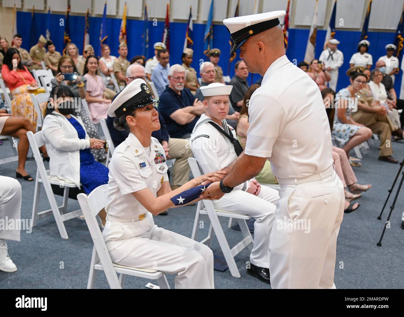 220603-N-UJ449-1402 MARINEFLUGSTATION SIGONELLA, Italien (03. Juni 2022)— Marineflugstation Sigonella Kommandomeisterin Anna Wood, erhält eine Flagge von ihrem Mann US Navy Medicine and Readiness Training Command Sigonella Command Master Chief Albert Wood, während seiner Ruhestandsfeier auf NAS Sigonella, 03. Juni 2022. Die strategische Lage von NAS Sigonella ermöglicht es den US-Streitkräften, den alliierten Streitkräften und den Streitkräften der Partnerstaaten, bei Bedarf zu entsenden und zu reagieren, um Sicherheit und Stabilität in Europa, Afrika und dem Zentralkommando zu gewährleisten. Stockfoto