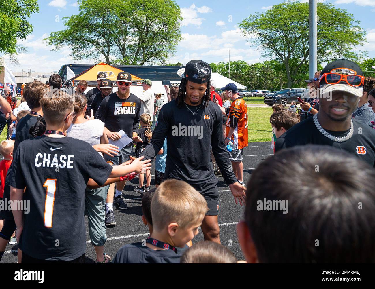 Kinder, die an der VON DER USO gesponserten bengalischen Kompetenzklinik teilnehmen, begrüßen Cincinnati Bengal Allan George (Zentrum) und andere Teamanfänger auf dem Luftwaffenstützpunkt Wright-Patterson, Ohio, 3. Juni 2022. Neunundneunzig Wright-Patt-Jugendliche hatten die Chance, ihre Fußballkünste mit den professionellen Spielern zu üben. Stockfoto