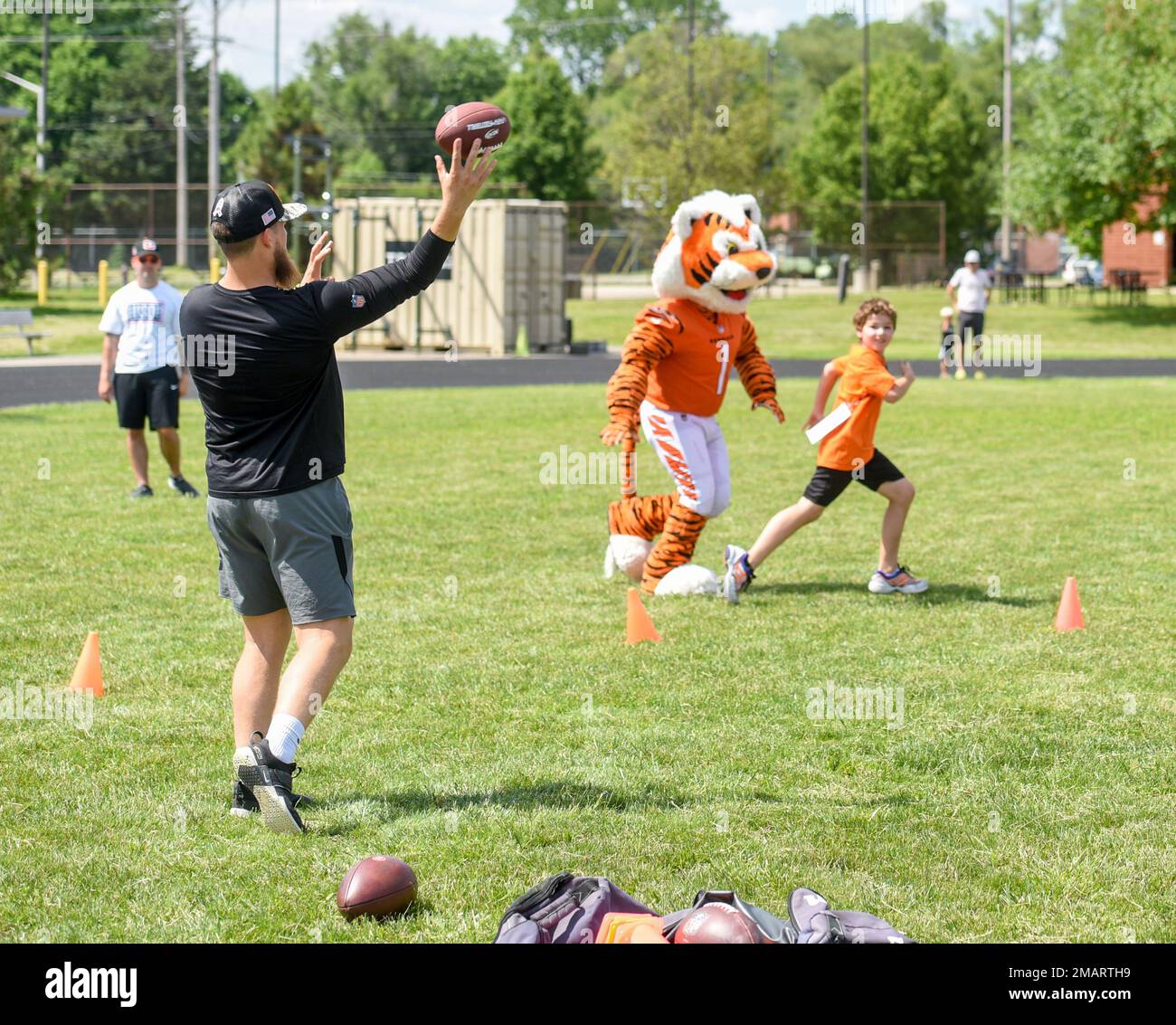 Cincinnati Bengals Long Snapper Cal Adomitis wirft einen Pass für eine Wright-Patterson Luftwaffenbasis, Ohio, Militärkind, als Who Dey in der VON DER USO gesponserten Cincinnati Bengals Football Skills Clinic verteidigt, 3. Juni 2022. Eine Gruppe bengalischer Neulinge aß mit Flugzeugen zu Mittag, besichtigte die Basis und leitete die Skills-Klinik für 99 Wright-Patt-Militärkinder. Stockfoto