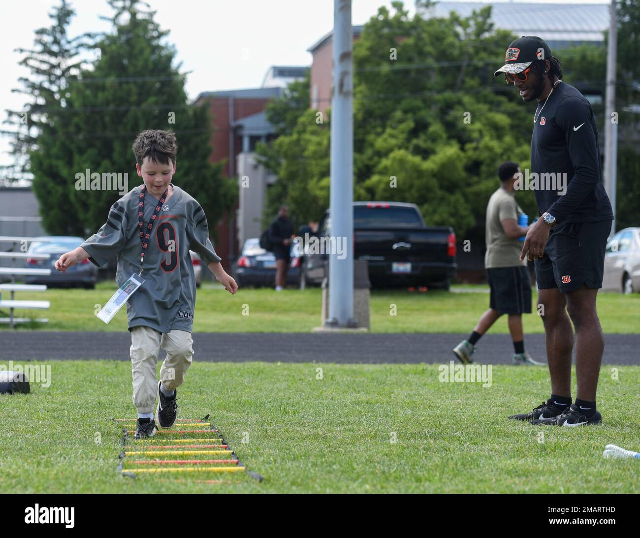 Cincinnati Bengals Cornerback Allan George jubelt einen Luftwaffenstützpunkt Wright-Patterson, Ohio, Militärkind in der VON DER USO gesponserten Cincinnati Bengals Football Skills Clinic, 3. Juni 2022. Eine Gruppe bengalischer Neulinge aß mit Flugzeugen zu Mittag, besichtigte die Basis und leitete die Skills-Klinik für 99 Wright-Patt-Militärkinder. Stockfoto