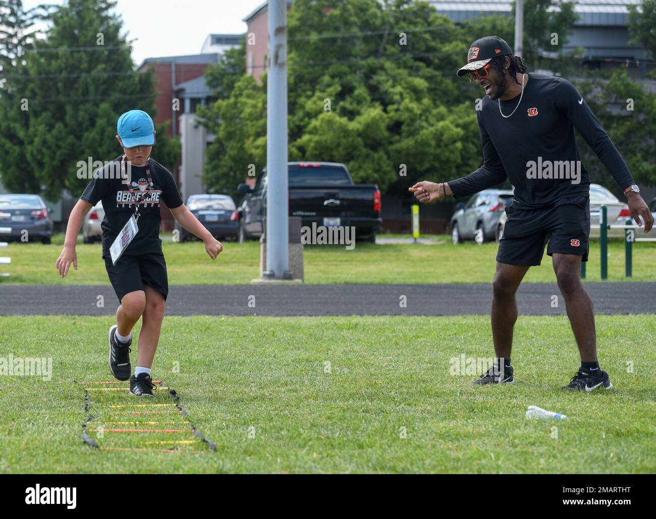 Cincinnati Bengals Cornerback Allan George jubelt einen Luftwaffenstützpunkt Wright-Patterson, Ohio, Militärkind in der VON DER USO gesponserten Cincinnati Bengals Football Skills Clinic, 3. Juni 2022. Eine Gruppe bengalischer Neulinge aß mit Flugzeugen zu Mittag, besichtigte die Basis und leitete die Skills-Klinik für 99 Wright-Patt-Militärkinder. Stockfoto