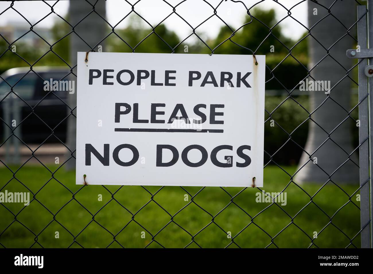 Ein Schild auf einem Zaun zu einem Park in Amerika mit der Aufschrift People Park Please no Dogs (People Park Bitte keine Hunde) Stockfoto