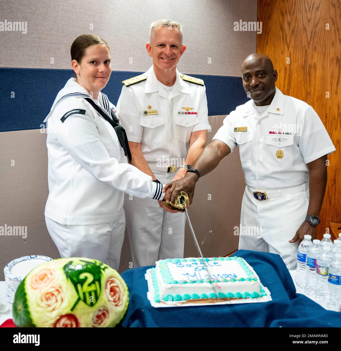 NORFOLK (6. Juni 2022) - Vice ADM. Daniel Dwyer, Center, Commander, U.S. 2. Fleet, Fleet Master Chief Huben Phillips, Right and Information Systems Technician 1. Class Elizabeth Lopez, Schnitt den Zeremoniekuchen während einer Gedenkzeremonie zur Schlacht um Midway, Juni 6. Diese Zeremonie war der 80. Jahrestag der Schlacht von Midway, die den Wendepunkt im Krieg im Pazifik während des Zweiten Weltkriegs bildete. Stockfoto