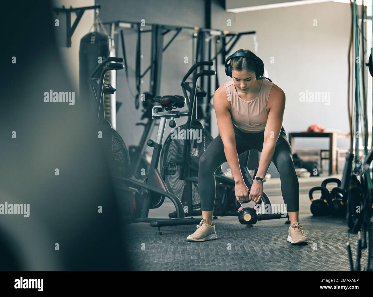 Kettlebell-Gewichte, Fitness-Gym-Frau mit Training, Training und Training mit Kopfhörern. Sportfokus, Wellness und gesunder Sportler, der mit Muskeln beschäftigt ist Stockfoto