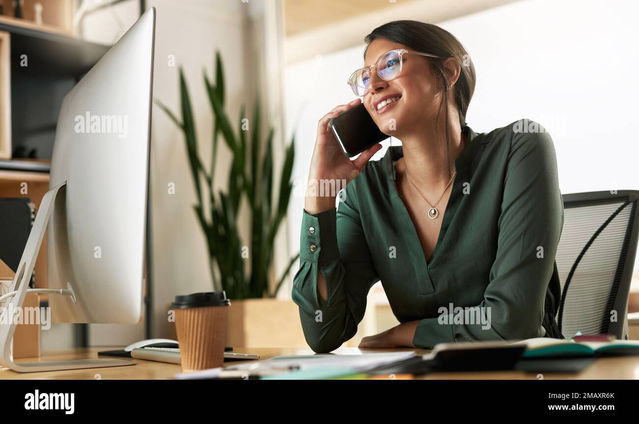 Ich habe deine Stimme verpasst. Eine junge Geschäftsfrau, die bei der Arbeit einen Anruf auf ihrem Smartphone entgegennimmt. Stockfoto