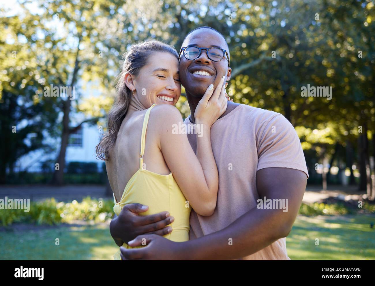 Liebe, zwischenmenschliche und Paare umarmen sich im Park, Verbundenheit und Glück für Romantik, Wellness und eine schöne Zeit zusammen. Romantisch, schwarzer Mann und Frau umarmen sich Stockfoto