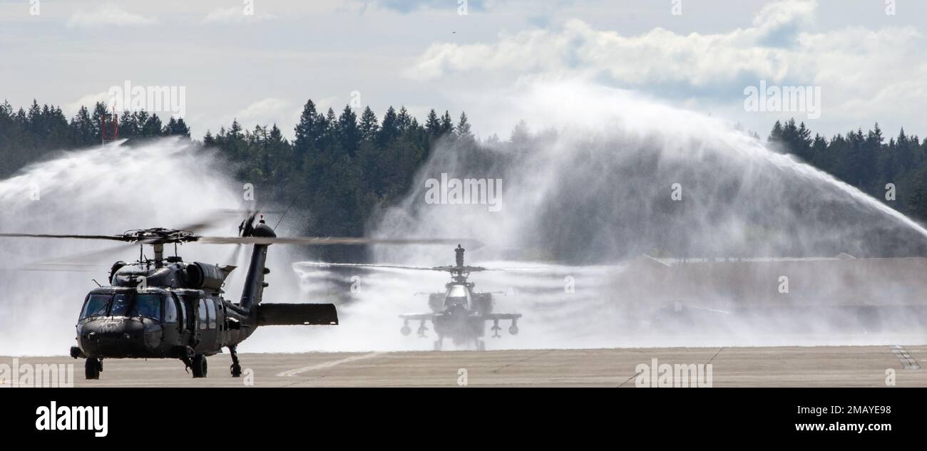 Oberstleutnant Kevin Easter, Befehlshaber des 1-229. Attack Bataillons, 16. Kampfluftfahrt-Brigade, taxis seinen AH-64E Apache-Helikopter durch seinen „Schlauch“ in Joint Base Lewis-McChord, Washington, am 8. Juni 2022. Oberstleutnant Simon Kim, Kommandant des 2-158. Angriffs-Helikopter-Bataillons, befindet sich im UH-60 Black Hawk im Vordergrund, und Oberstleutnant Eric Megerdoomian, Kommandant der 4-6. Kavallerie-Geschwader, ist im Hintergrund im Apachen. Alle drei Bataillonskommandeure führten gemeinsam ihre letzten Flüge durch. Stockfoto