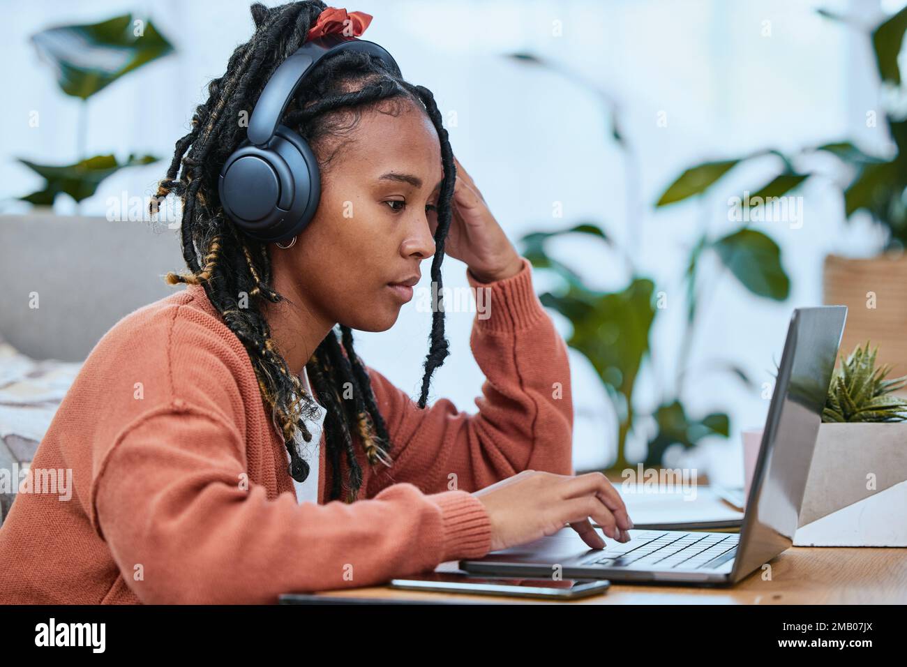 Denk, schwarze Frau und Laptop für Fernarbeit von zu Hause aus, Konzentration und Tippen mit Verbindung. Jamaikanerin, Dame und Freiberufler mit Audio Stockfoto