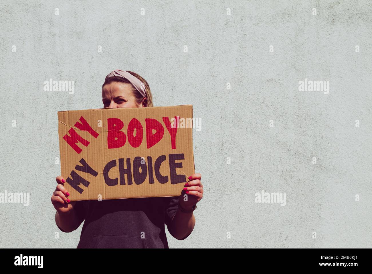 Frau mit Plakette und Schriftzug My Body My Choice während der Manifestation. Weibliche Protestprotestierin mit Banner bei der Protestkundgebung. Stockfoto