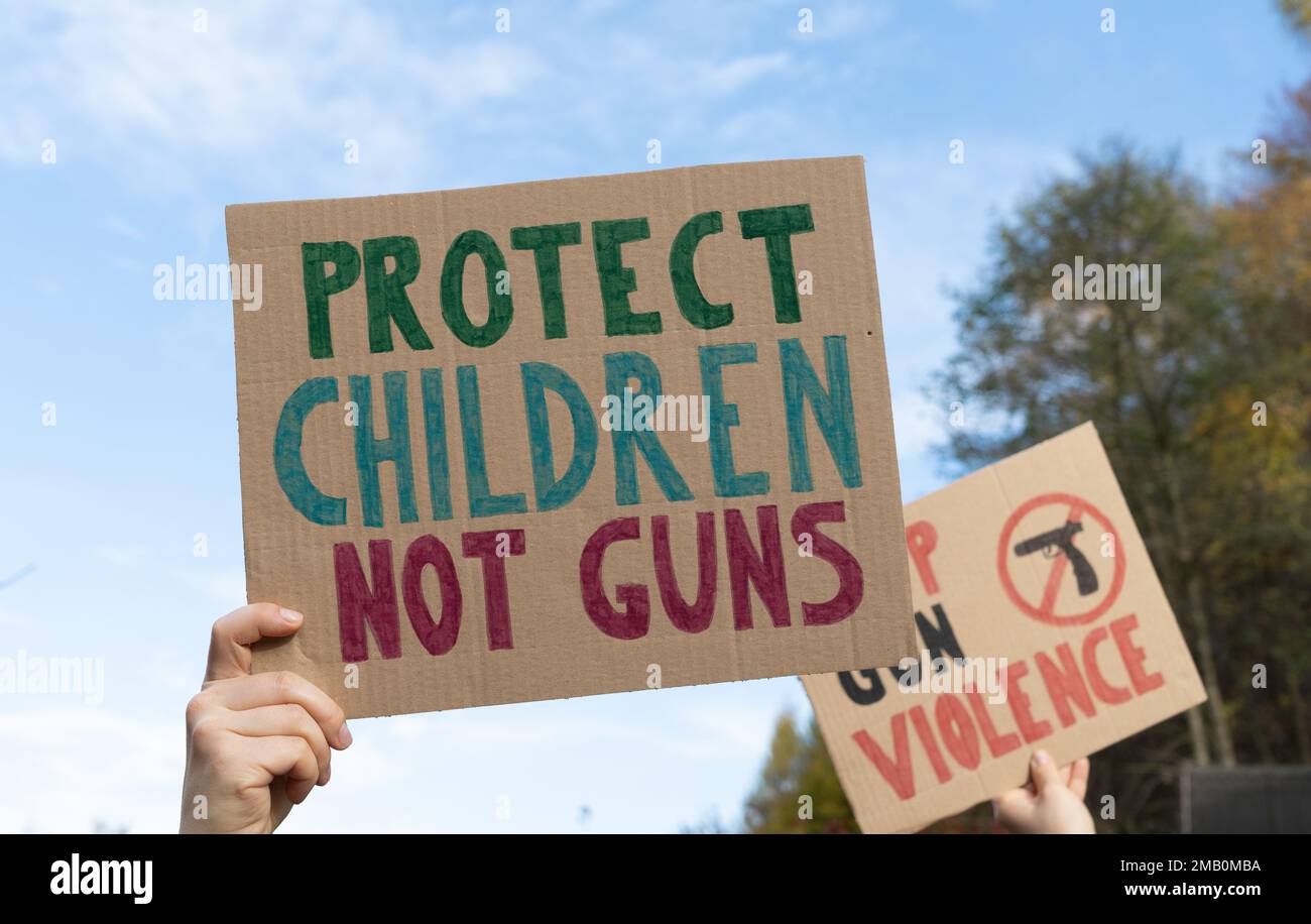 Demonstranten mit Schildern schützen Kinder, nicht Waffen, stoppen Waffengewalt. Menschen mit Plakaten bei der Protestdemonstration, Waffen zu verbieten und Schüsse zu beenden. Stockfoto