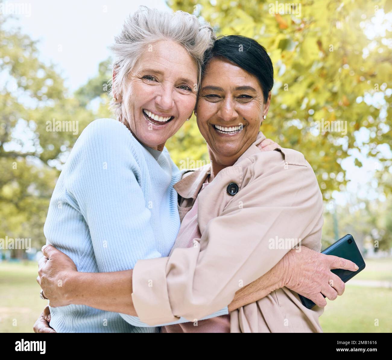 Seniorinnen, sich im Naturpark, im Garten oder in entspannter Umgebung anfreunden oder ein Porträt umarmen, um soziale Medien, Profilbilder oder Erinnerungen zu nutzen. Lächeln, glückliche Freunde oder Stockfoto