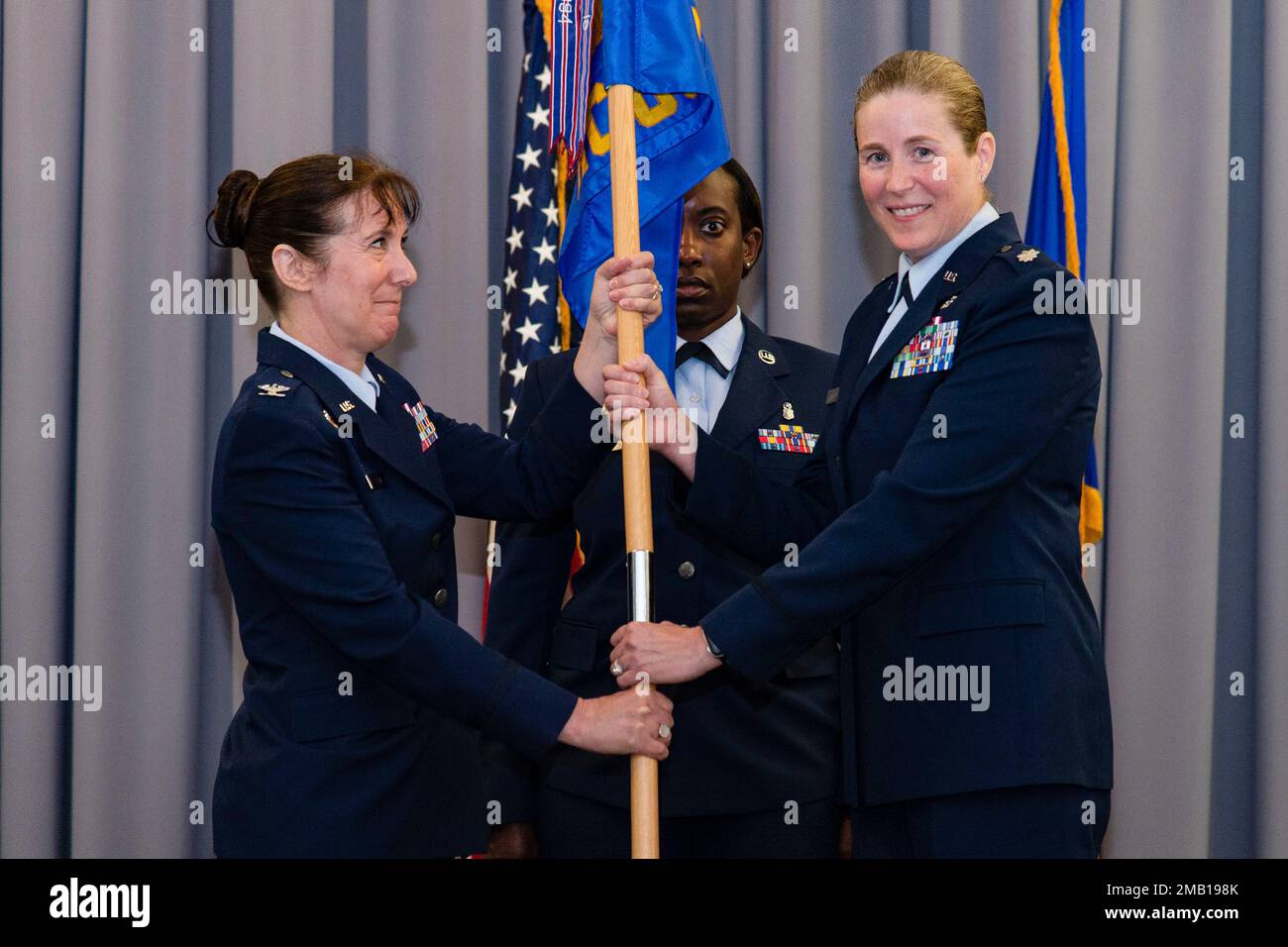 LT. Oberst Brittany Nutt, 436. Geschwaderkommandant der Health Care Operations, rechts, gibt das Kommando über die 436. HCOS auf, nachdem er den Guidon an Oberst Tracy Allen, links, 436. Medical Group Commander, übergeben hat, während einer Zeremonie zum Kommandowechsel an der Landung auf der Dover Air Force Base, Delaware, 9. Juni 2022. Der HCOS-Kommandowechsel 436. war eine von vier Zeremonien, die im Rahmen der Millenniums-Entwicklungsziele 436. durchgeführt wurden. Guidon übernahm die Zeremonie mit Master Sgt. Kimberly Hammonds, Center, 436. HCOS Superintendent. Stockfoto