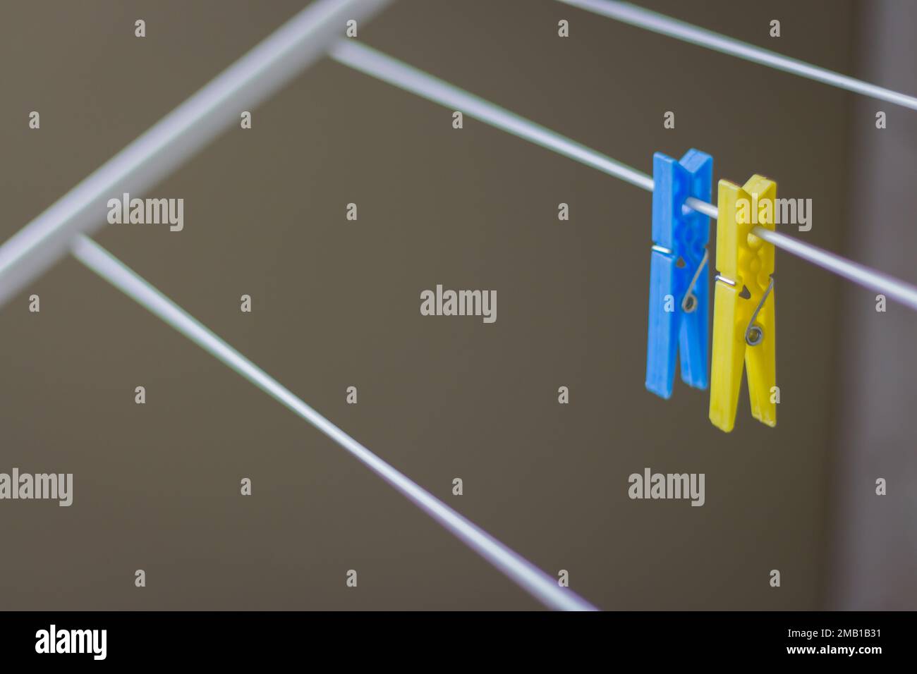 Kleiderhaken an der Wäscheleine. Kleidernadeln an der Wäscheleine. Kleidernadel in ukrainischen Farben. Blauer und gelber Stift Wäschekonzept. Haushaltsgeräte Stockfoto