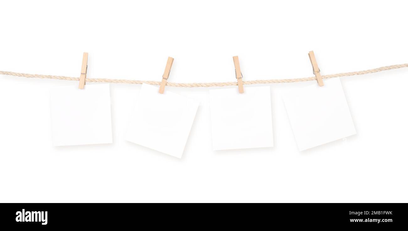 Vier leere quadratische Notizblöcke, die an einem Seil befestigt sind, isoliert auf weißem Hintergrund. Beschneidungspfad Enthalten. Stockfoto