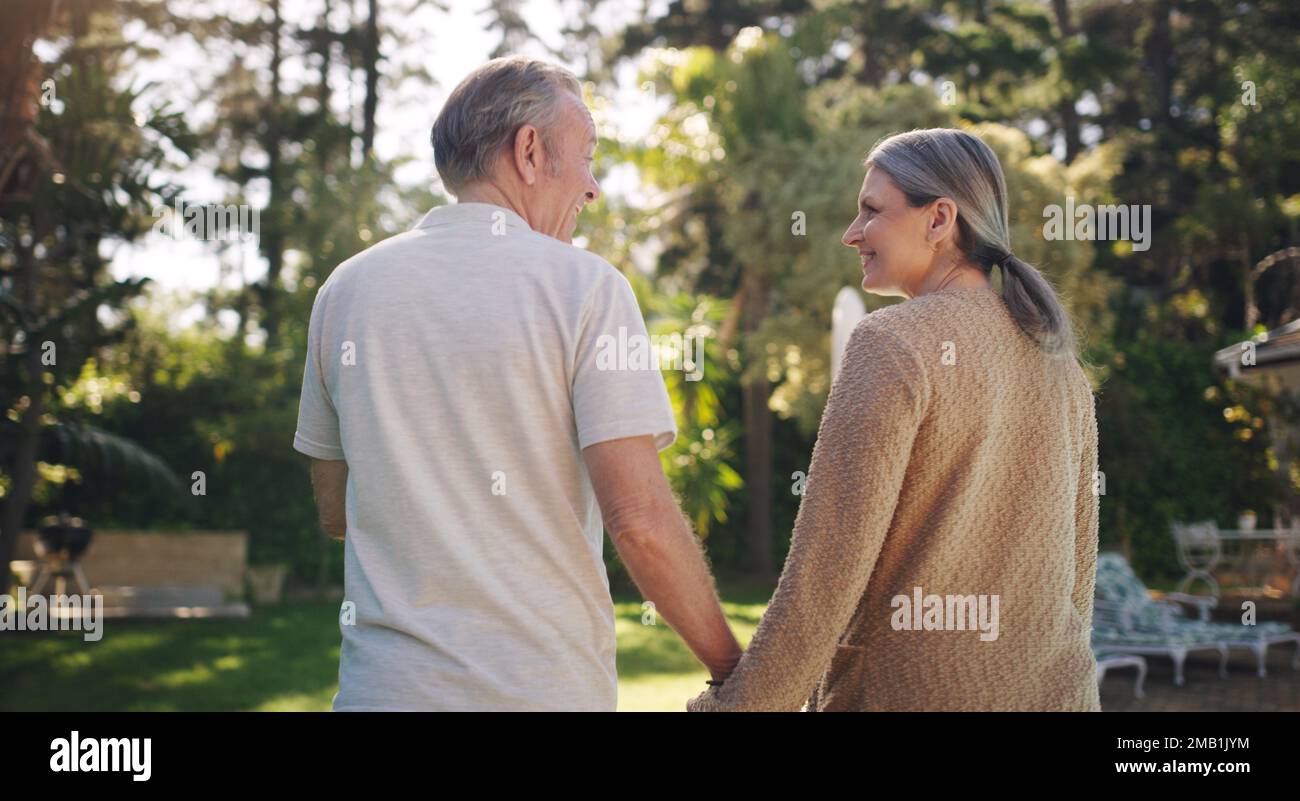 Mit dir alt zu werden, ist meine Freude. Ein reifes Paar, das einen Spaziergang in seinem Garten genießt. Stockfoto
