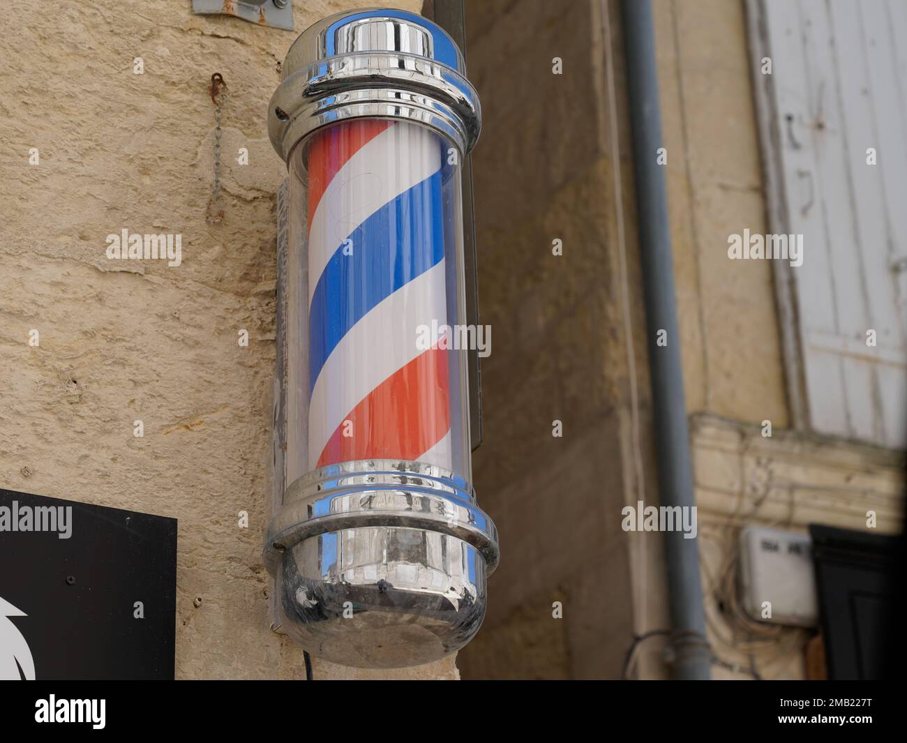 Barberständer-Shop-Schild zylindrisches Schild in alten Friseurwänden weiß rot-blau Stockfoto