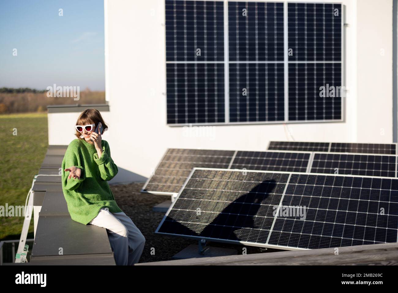 Eine Frau auf dem Dach ihres Hauses mit einer Solarstation Stockfoto