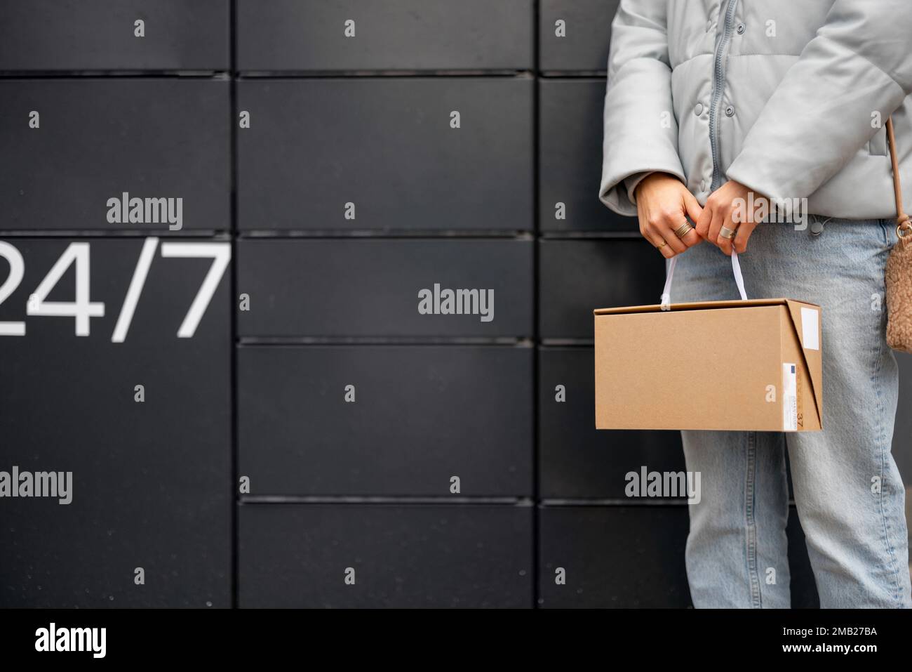 Ein Paket auf dem Hintergrund einer automatischen Postmaschine halten Stockfoto
