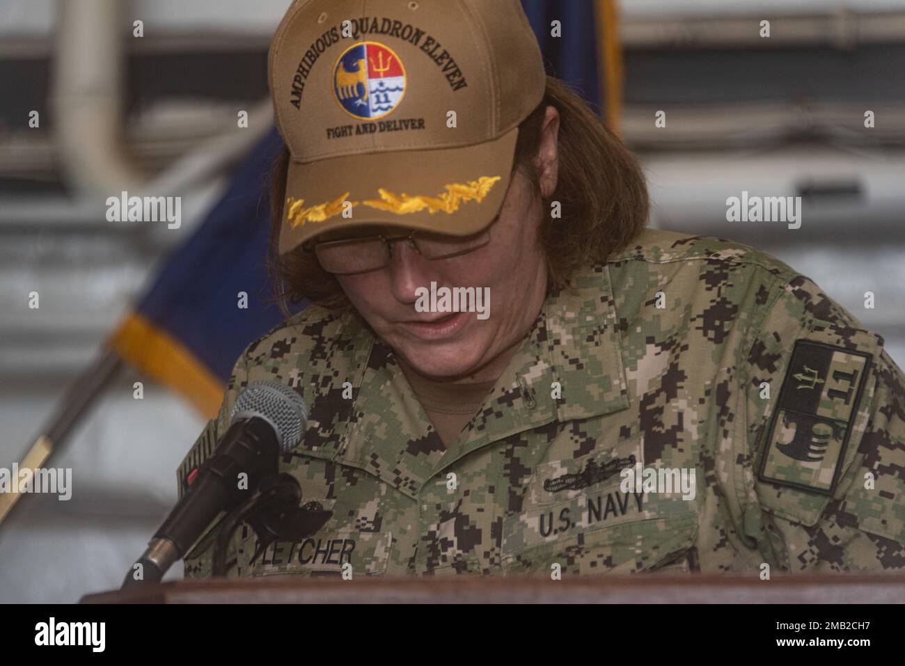 220610-N-XB010-1008 SASEBO, Japan (6. Juni 2022) Captain Kelly T. Fletcher liest ihre Befehle während seiner Zeremonie zum Befehlswechsel in der Hangarbucht des vorwärts eingesetzten Amphibienschiffs USS New Orleans (LPD 18). Das Amphibiengeschwader 11 ist im Zuständigkeitsbereich der US-amerikanischen 7.-Flotte tätig, um die Interoperabilität mit Verbündeten und Partnern zu verbessern und als einsatzbereite Eingreiftruppe zur Verteidigung von Frieden und Stabilität im Indo-Pazifik-Raum zu dienen. Stockfoto